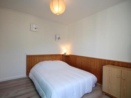 - une chambre avec un lit blanc éclairé dans l'établissement Appartement T3 au Mont-Dore avec WIFI et balcon, près du centre - FR-1-608-84, à Le Mont-Dore
