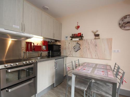 - une cuisine avec une table, une table et des chaises dans l'établissement Charmant T2 dans hyper-centre avec wifi et balcon - Le Mont-Dore - FR-1-608-75, à Le Mont-Dore