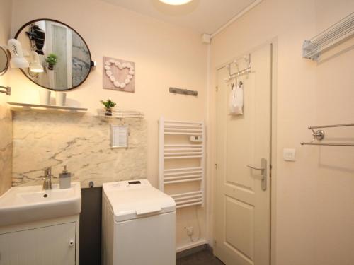 une salle de bain avec un lavabo et un miroir dans l'établissement Charmant T2 dans hyper-centre avec wifi et balcon - Le Mont-Dore - FR-1-608-75, à Le Mont-Dore