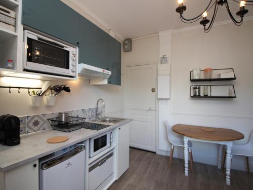 une petite cuisine avec un évier et une table dans l'établissement Mont-Dore Centre: T2 Bis 4 Pers, Wifi, Tout Équipé - FR-1-608-89, à Le Mont-Dore
