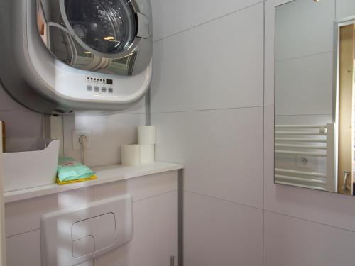 La salle de bains est pourvue d'un lave-linge sur le mur. dans l'établissement Mont-Dore Centre: T2 Bis 4 Pers, Wifi, Tout Équipé - FR-1-608-89, à Le Mont-Dore