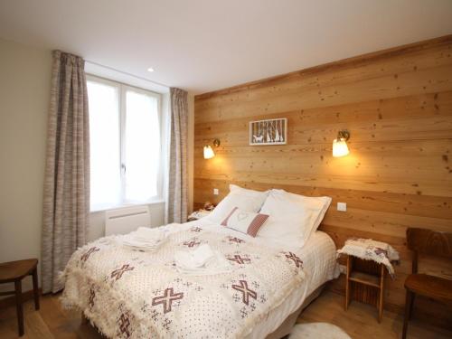 a bedroom with a bed with a wooden wall at Mont-Dore : T2 spacieux avec terrasse, 300m des thermes, résidence rénovée, parking privé - FR-1-608-98 in Le Mont-Dore