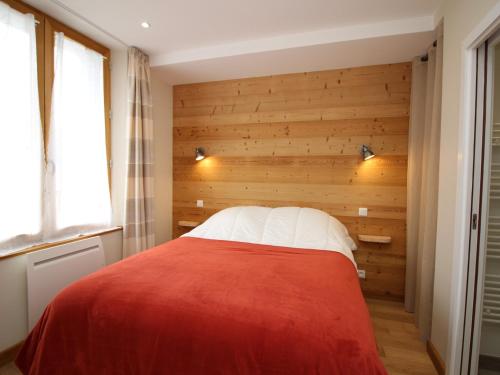 ein Schlafzimmer mit einem Bett mit einer Holzwand in der Unterkunft T2 de Standing à 300m des Thermes du Mont-Dore avec Parking et Ascenseur - FR-1-608-99 in Le Mont-Dore