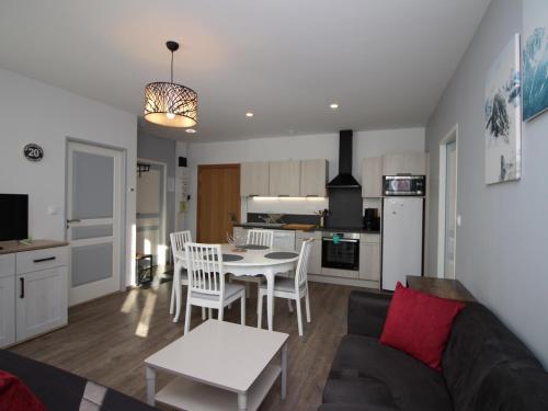 un salon avec un canapé et une table et une cuisine dans l'établissement Bel Appartement T3 avec WIFI et Parking, Résidence de Standing, 300m des Thermes au Mont-Dore - FR-1-608-87, à Le Mont-Dore
