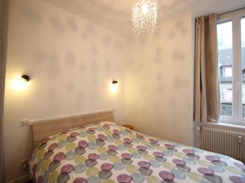 a bedroom with a bed and a window and a chandelier at Appartement La Bourboule, 3 pièces, 5 personnes - FR-1-608-96 in La Bourboule