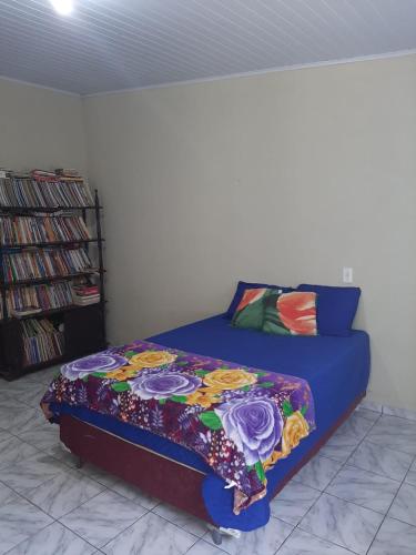 a bedroom with a bed with a colorful blanket at Pousada Recanto do Galo in Santa Cruz Cabrália