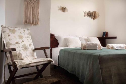 una camera con un letto e una sedia accanto a un letto di Casa Alba a Marina di Pescoluse