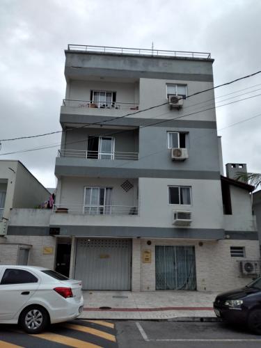 a white car parked in front of a building at Cantinho da Ro in Balneário Camboriú