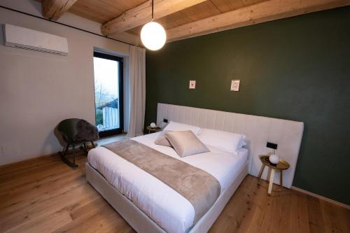 Un dormitorio con una cama grande y una pared verde en La Casa nel Relais, en Novello
