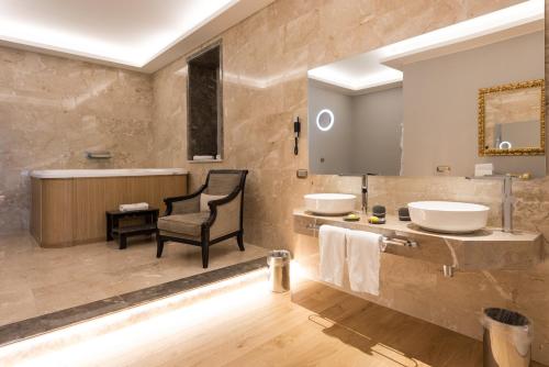 a bathroom with two sinks and a chair at Grand Hotel Et Des Palmes in Palermo