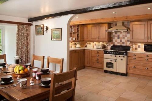 a kitchen with a wooden table and a dining room at Scenic Welsh Cottage in the Brecon Beacons in Crickhowell