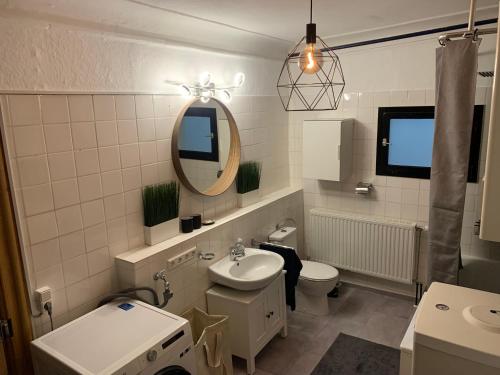 uma casa de banho com um lavatório, um WC e um espelho. em Marktplatz Memmingen em Memmingen