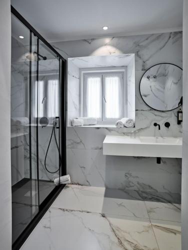 a white bathroom with a shower and a sink at The Bastion Elvas Apartments in Elvas
