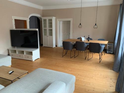 a living room with a table with chairs and a television at Marktplatz Memmingen in Memmingen