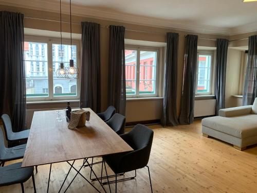 a living room with a wooden table and chairs at Marktplatz Memmingen in Memmingen