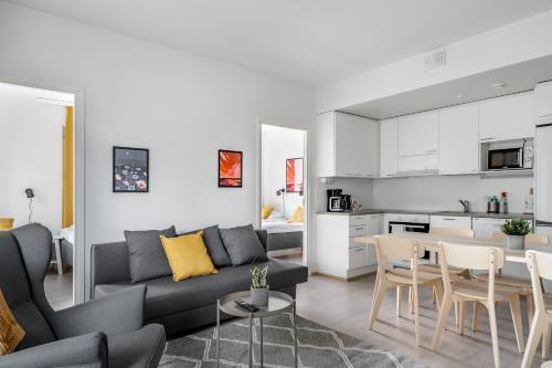 a living room and kitchen with a couch and a table at Hiisi Homes Turku Ratapiha in Turku