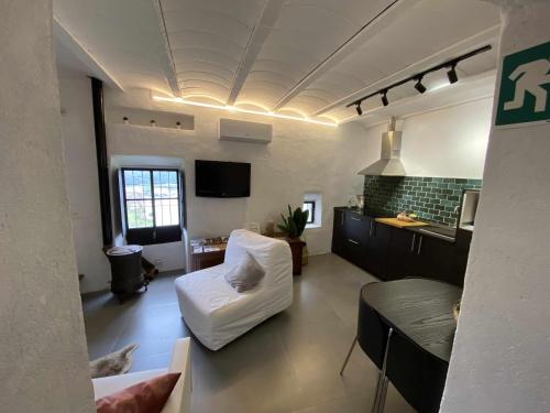 a living room with a white couch and a kitchen at La Martela de Fuentes Casa de diseño rural in Fuentes de León