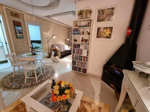 坎普斯杜若爾當的住宿－Flat com lareira em Campos do Jordão，一间带桌子的客厅和一间带沙发的客厅