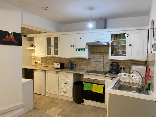 a kitchen with white cabinets and a sink at Calm residential house in Wyken