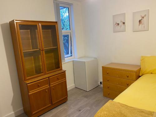 a bedroom with a large wooden cabinet and a bed at Calm residential house in Wyken