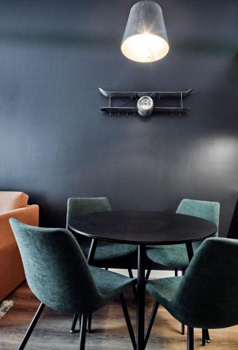 a table with green chairs and a clock on a wall at The Bastion Elvas Apartments in Elvas
