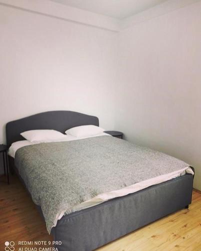 a bed in a room with a white wall at Bellevue in Zlatibor