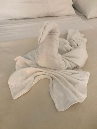 a white towel sitting on top of a bed at Owen Home Holiday in Castelsardo