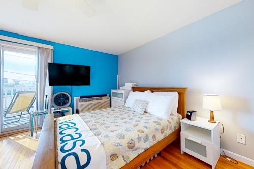 a bedroom with a bed and a flat screen tv at Little Gem at Hampton Beach in Hampton