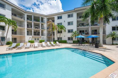 a swimming pool in front of a building with a hotel at Updated Beach Condo! Facing Heated Pool & Sunset! in Naples