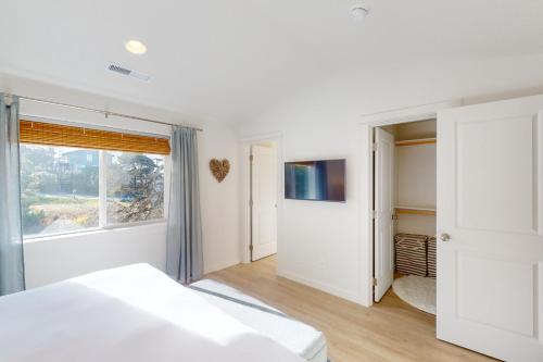 a white bedroom with a bed and a window at Turquoise Dreams in Lincoln City