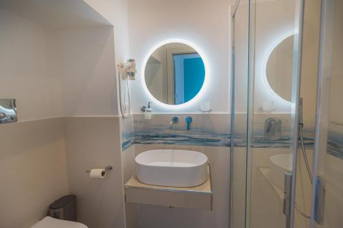 a bathroom with a toilet and a sink and a mirror at Panorama Alfeo in Siracusa