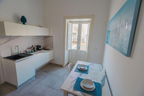 a small kitchen with a table and a sink at Panorama Alfeo in Siracusa