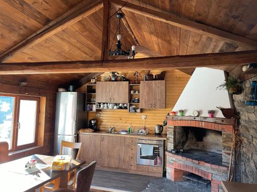 uma cozinha com lareira numa casa de madeira em Къща за гости Виевци em Vievo
