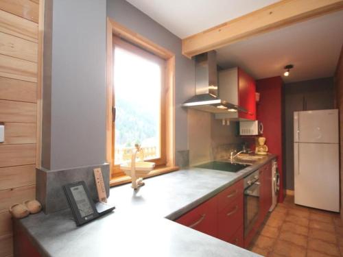 une cuisine avec un comptoir et une grande fenêtre dans l'établissement Chalet confortable 3 étoiles avec terrasse au Mont-Dore - 6 pers., 2 chambres, WIFI - FR-1-608-10, à Le Mont-Dore