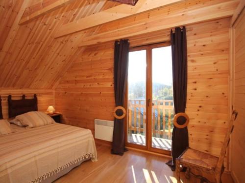 a bedroom with a bed and a large window at Chalet confortable 3 étoiles avec terrasse au Mont-Dore - 6 pers., 2 chambres, WIFI - FR-1-608-10 in Le Mont-Dore