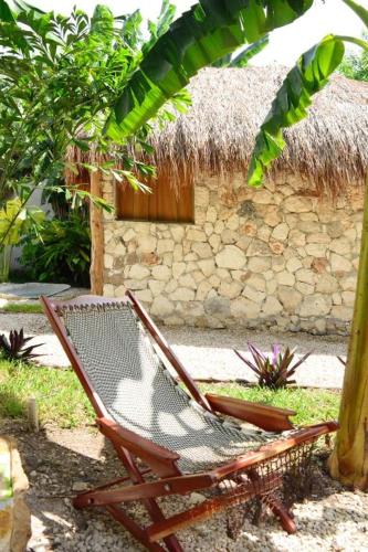a chair sitting in front of a building at Aldea Che-Eek , con acceso a un club de playa privado in Bacalar