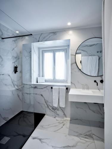 a white bathroom with a sink and a mirror at The Bastion Elvas Apartments in Elvas