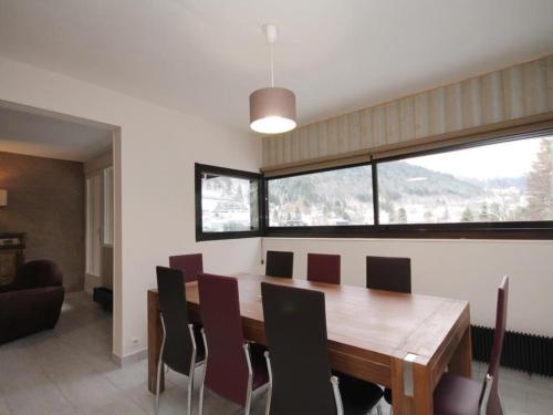 une salle à manger avec une table et des chaises en bois dans l'établissement Appartement T4 dernier étage au centre avec wifi et parking - FR-1-608-9, à Le Mont-Dore