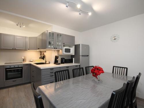 une cuisine avec une table avec un vase de fleurs dessus dans l'établissement Mont-Dore : Duplex 4P avec Balcon, Garage et Wi-Fi - FR-1-608-3, à Le Mont-Dore