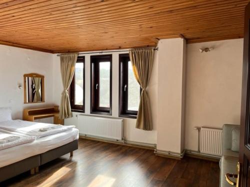 - une chambre avec un lit et quelques fenêtres dans l'établissement Бор и Шишарка, 