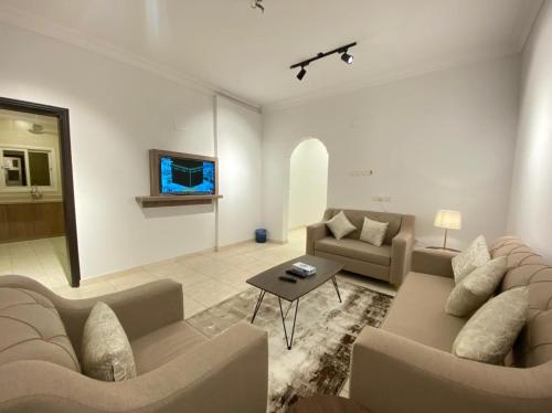 ein Wohnzimmer mit 2 Sofas und einem Tisch in der Unterkunft نايتس للوحدات المفروشة in Tabuk