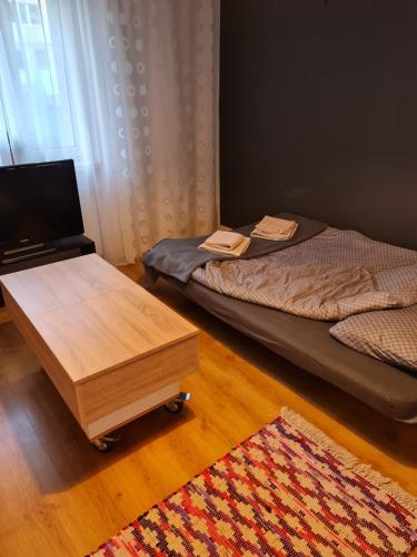 a room with two beds and a table and a rug at Przytulny apartament blisko centrum in Katowice