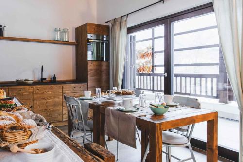Coste del Gaggio - Country House B&B - Garda Trentino في Drena: غرفة طعام مع طاولة مع كراسي ونافذة