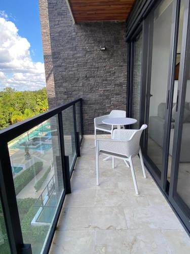 a patio with a table and chairs on a balcony at LUXURY spacious Condo Option with 1 or 2 or 3 Bedrooms, PGA Golf, Gym, Kay Beach Club in Kaan Ha Akumal in Akumal