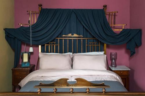 um quarto com uma grande cama de dossel azul em Rumple Cottage em Wingfield