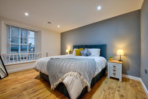 a bedroom with a large bed and a window at Stylish Stamford Centre 2 Bedroom Apartment With Parking - St Pauls Apartments - A in Stamford