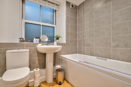 uma casa de banho com um WC, um lavatório e uma banheira em Stylish Stamford Centre 2 Bedroom Apartment With Parking - St Pauls Apartments - A em Stamford