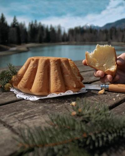 une personne tenant un morceau de pain et un morceau de gâteau dans l'établissement Calme et sérénité - établissement classé, à Sixt-Fer-à-Cheval