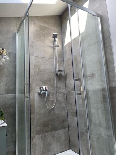 a shower with a glass door in a bathroom at Figtrees in Margueron