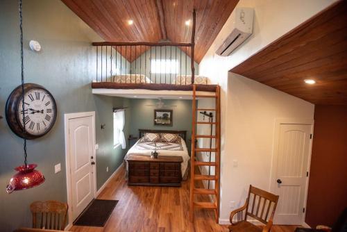 a bedroom with a bunk bed and a clock at Cowbell Cabin 15min to Downtown Waco in Waco